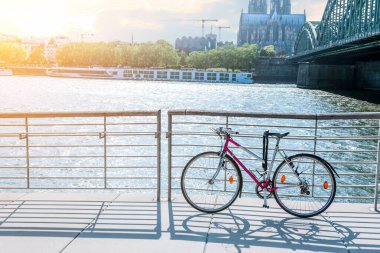 Şehirdeki nehir kenarına park edilmiş modern bir bisiklet.