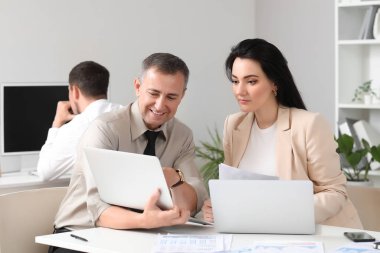 Ofiste dizüstü bilgisayarla çalışan iş danışmanları.