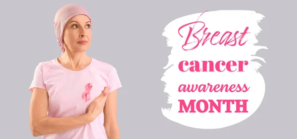 stock image Mature woman after chemotherapy with pink ribbon on grey background. Breast cancer awareness month