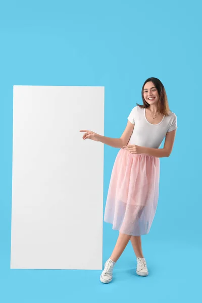 Young Woman Pointing Big Blank Poster Blue Background — Stock Photo, Image