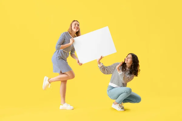 Young Women Big Blank Poster Yellow Background — Stock Photo, Image