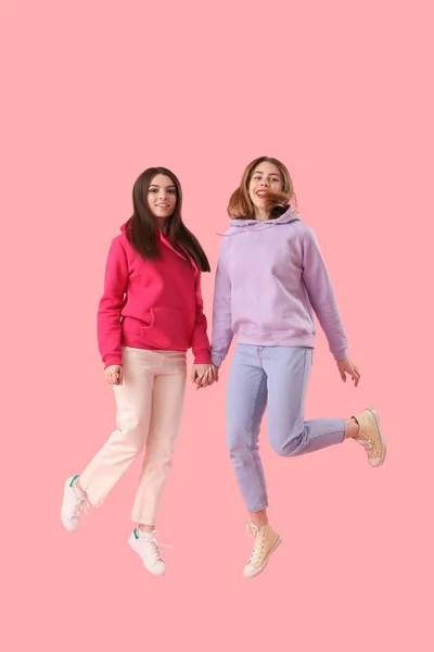 Freundinnen Springen Auf Rosa Hintergrund — Stockfoto