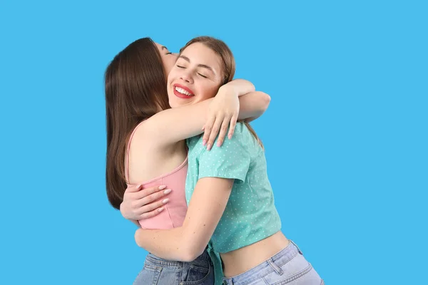 在蓝色背景下拥抱的女性朋友 — 图库照片