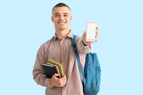 Mężczyzna Student Plecakiem Książki Telefon Komórkowy Niebieskim Tle — Zdjęcie stockowe