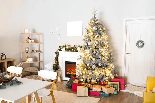 リビングルームのインテリアに輝く光と贈り物とクリスマスツリー — ストック写真