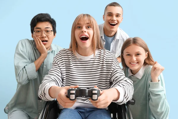 Группа Подростков Девушкой Инвалидной Коляске Играют Видеоигры Синем Фоне — стоковое фото