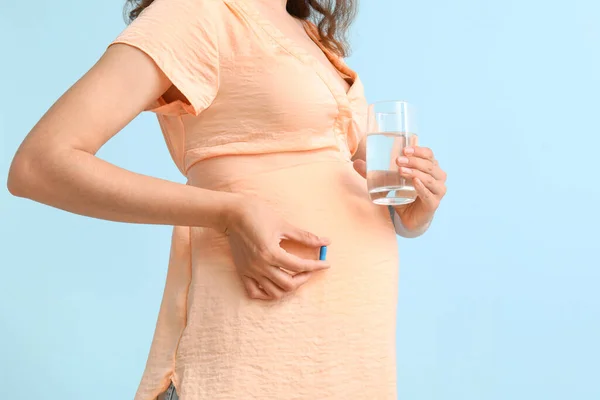 Молодая Беременная Женщина Стаканом Воды Фолиевой Кислоты Таблетки Синем Фоне — стоковое фото