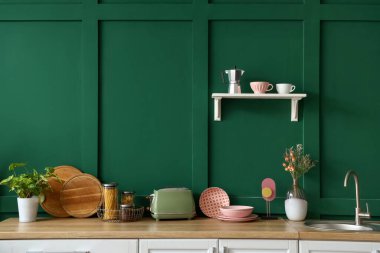 Modern mutfakta elektrikli ekmek kızartma makineli ahşap tezgah, tabak ve çatal bıçak.