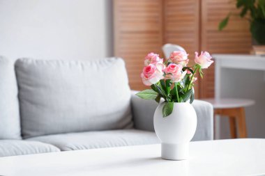 Oturma odasında üzerinde güller olan vazo, yakın plan.