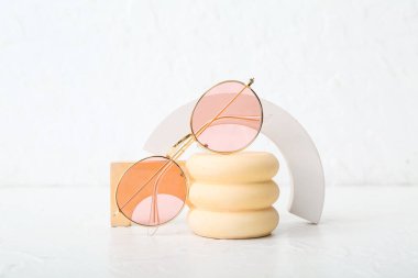 Beyaz arka planda şık güneş gözlüklü dekoratif podyumlar