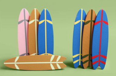 Yeşil arka planda farklı mini sörf tahtaları