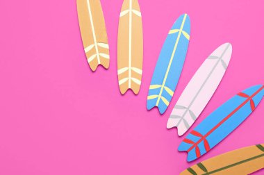 Pembe arka planda farklı mini sörf tahtaları