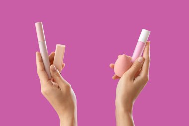 Mor arka planda makyaj ürünleri olan kadın.