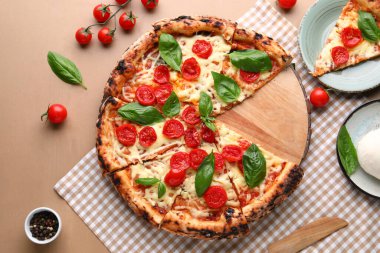 Kahverengi ahşap arka planda taze domatesli lezzetli bir pizza.