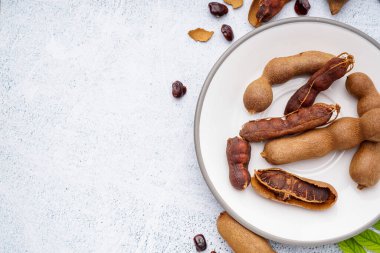 Beyaz arkaplanda lezzetli tamarindlerin tabağı