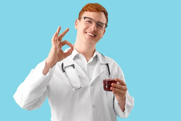 Αρσενικός Γιατρός Ποτήρι Χυμό Δείχνει Μπλε Φόντο — Φωτογραφία Αρχείου
