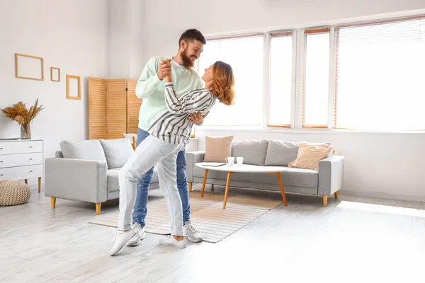 Happy couple in love dancing at home
