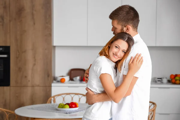 Stock image Happy couple in love hugging in kitchen