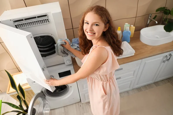 Young woman with drying machine at home