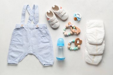 Bebek aksesuarları ve açık arkaplanda giysileri olan kompozisyon