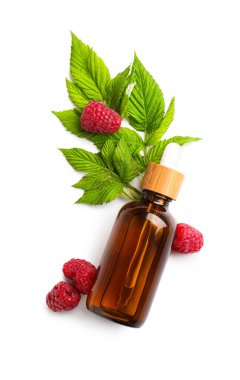 Beyaz arka planda bir şişe kozmetik ahududu yağı