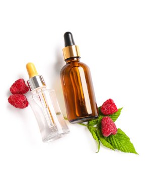 Beyaz arka planda kozmetik ahududu yağı şişeleri