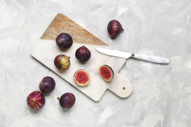 Gri arka planda taze olgun incirleri olan tahta