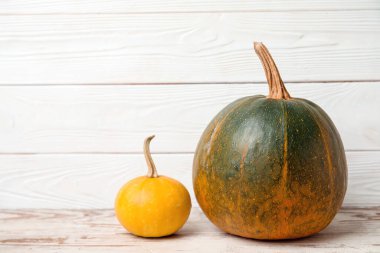 Beyaz ahşap arka planda farklı taze balkabakları