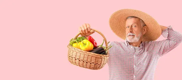 Ältere Männliche Bauer Mit Weidenkorb Voller Verschiedene Gemüse Auf Rosa — Stockfoto