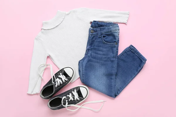 粉红背景的时髦儿童毛衣 牛仔裤和鞋子 — 图库照片