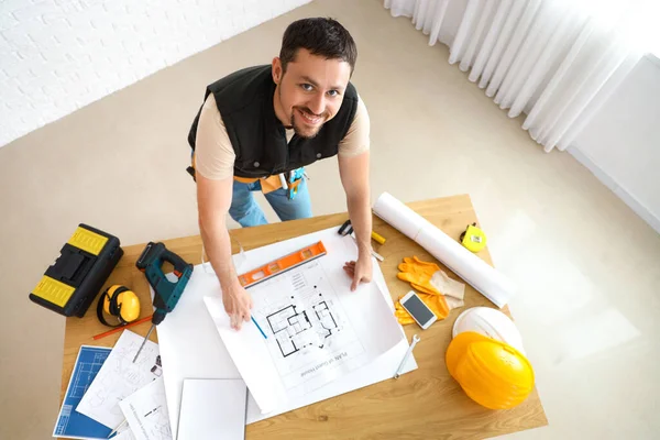 男建筑工人在房间内的桌子上做住房计划 — 图库照片