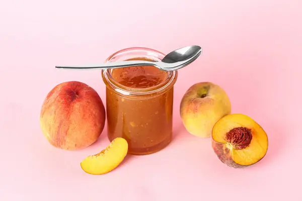 Glas Mit Süßer Pfirsichmarmelade Und Frischen Früchten Auf Rosa Hintergrund — Stockfoto