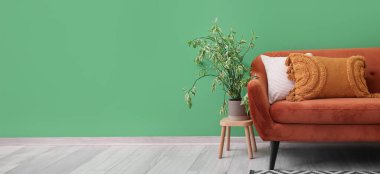 Yumuşak yastıklı, yeşil duvarlı rahat bir kanepe. Tasarım için pankart