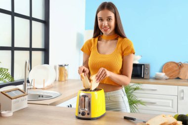 Genç bayan mutfakta kadeh kaldırıyor.