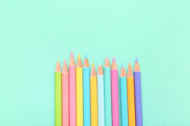 Turkuaz arka planda birçok renkli kalem