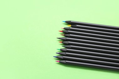 Yeşil arka planda birçok farklı renkli kalemler