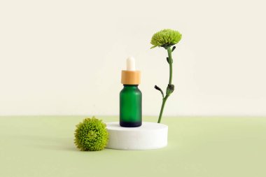 Gerekli yağ şişesi, sıva podyumu ve arkaplanda güzel kasımpatı çiçekleri olan kompozisyon