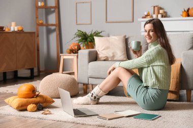 Evde çay içip ders çalışan genç bir kadın.