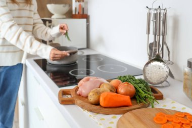Mutfaktaki masada, içinde tavuk çorbası malzemeleri olan pano, yakın plan.