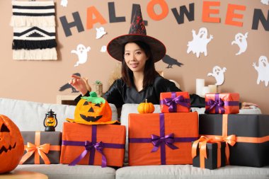 Cadılar Bayramı 'nı evde kutlayan cadı kılığındaki genç Asyalı kadın.