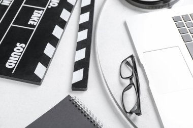 Beyaz arka planda gözlüklü ve dizüstü bilgisayarı olan film alkışlayıcısı, yakın plan