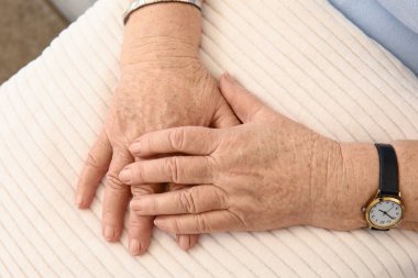 Yastıklı yaşlı kadın evde oturuyor, yakın plan.