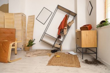 Çekmeceler ve askılar dağınık odada.