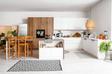 Ahşap masadaki modern aletlerle aydınlık mutfağın içinde.