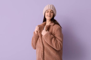 Leylak arkaplanda oyuncak ceketli genç bir kadın.