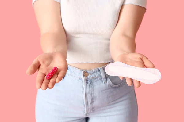 月経パッドとピンクの背景にタンポンを持つ若い女性 クローズアップ — ストック写真