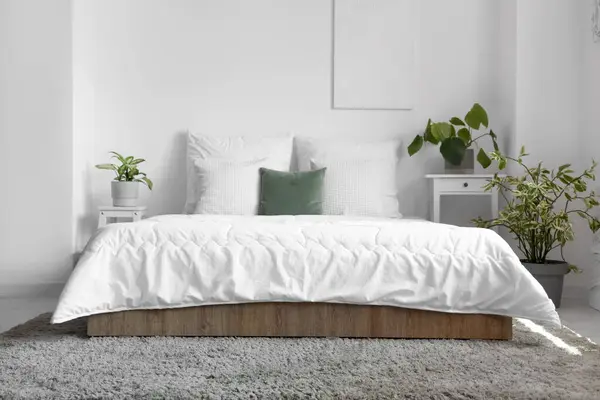 舒适的床 有白色的毯子和枕头在轻便卧室的内部 — 图库照片