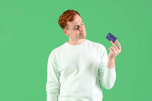Bedachtzame Jonge Roodharige Man Met Credit Card Groene Achtergrond — Stockfoto