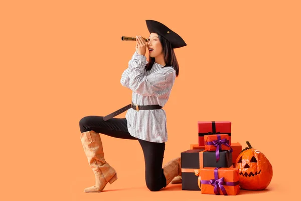 Młoda Azjatka Ubrana Jak Pirat Lunetą Prezentów Halloween Pomarańczowym Tle — Zdjęcie stockowe
