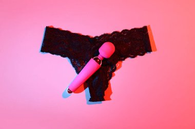 Kırmızı arka planda iç çamaşırı olan vibratör.